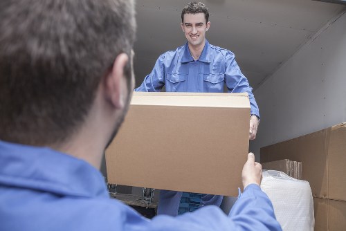 Movers handling furniture with protective packing and safety focus